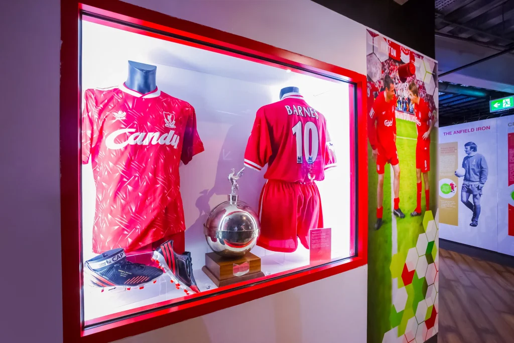 Liverpool FC jerseys, football boots, trophy.