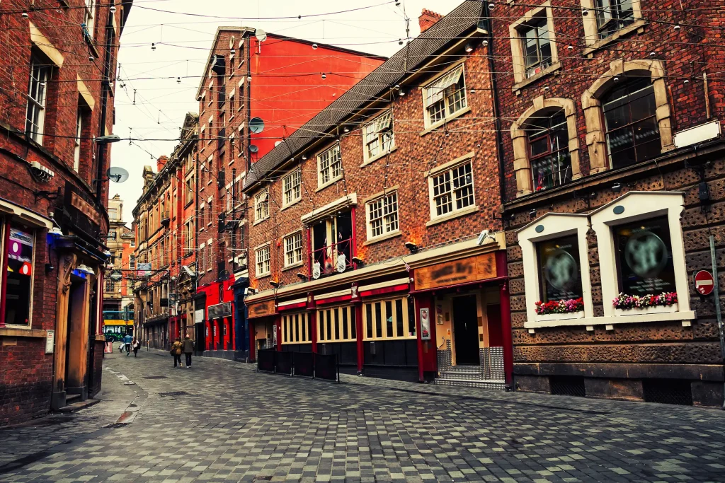 Historic brick buildings, charming cobbled street.
